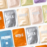 Collection of colorful korean beauty facial mask packets on a white background