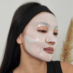 Woman wearing lapcos overnight sheet mask on face in two parts (top + bottom)