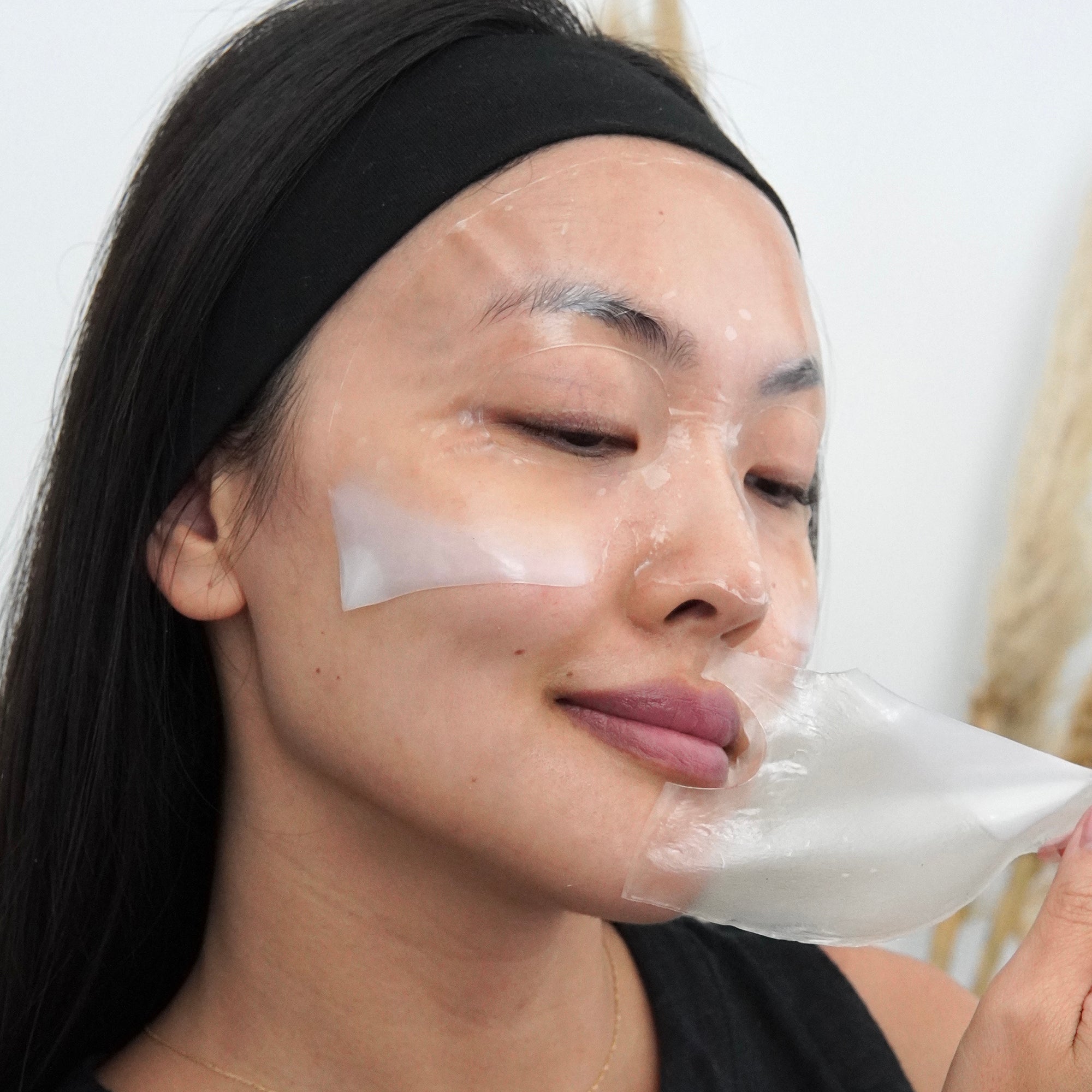 Woman removing LAPCOS overnight collagen sheet mask from face