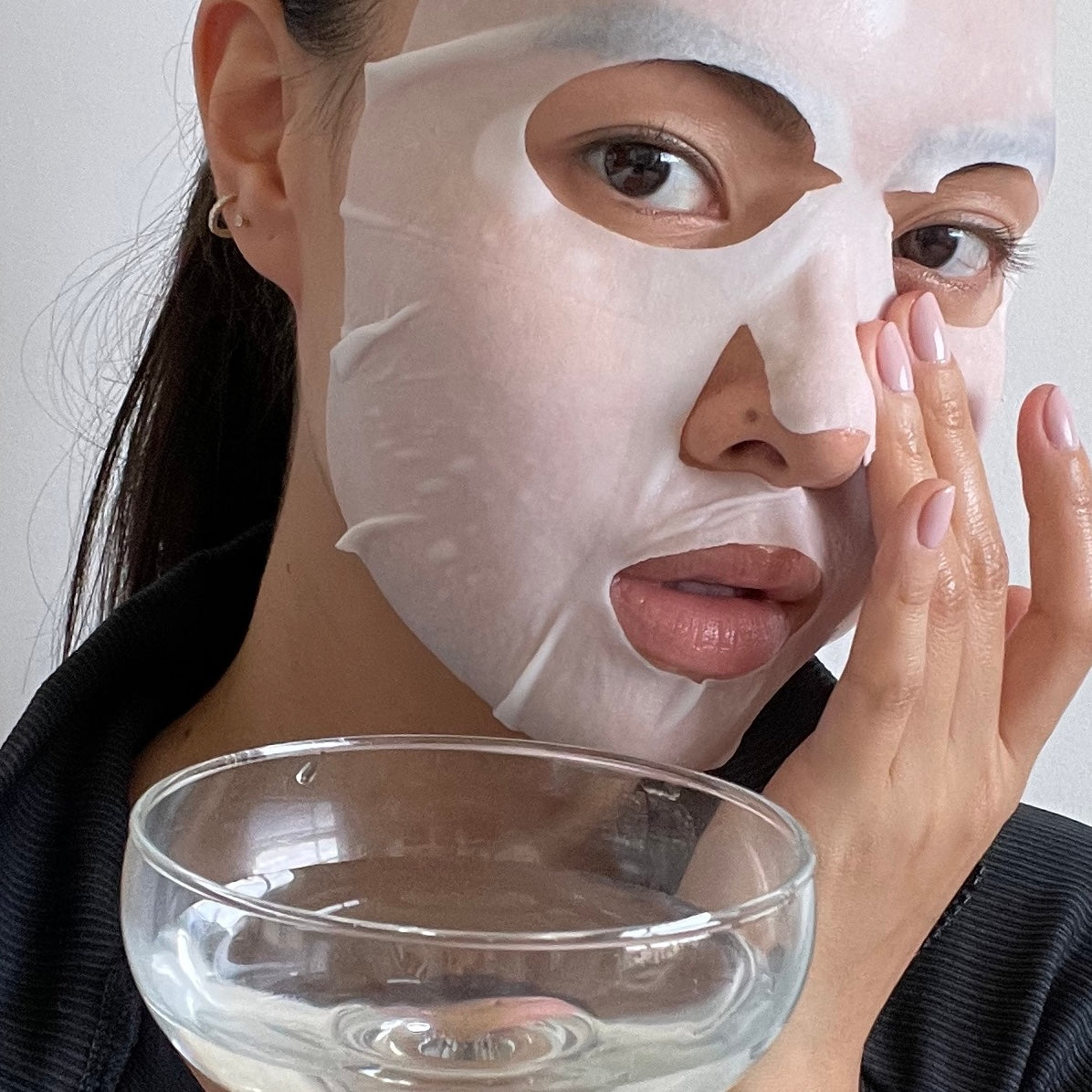 Woman applying a facial mask by LAPCOS k beauty